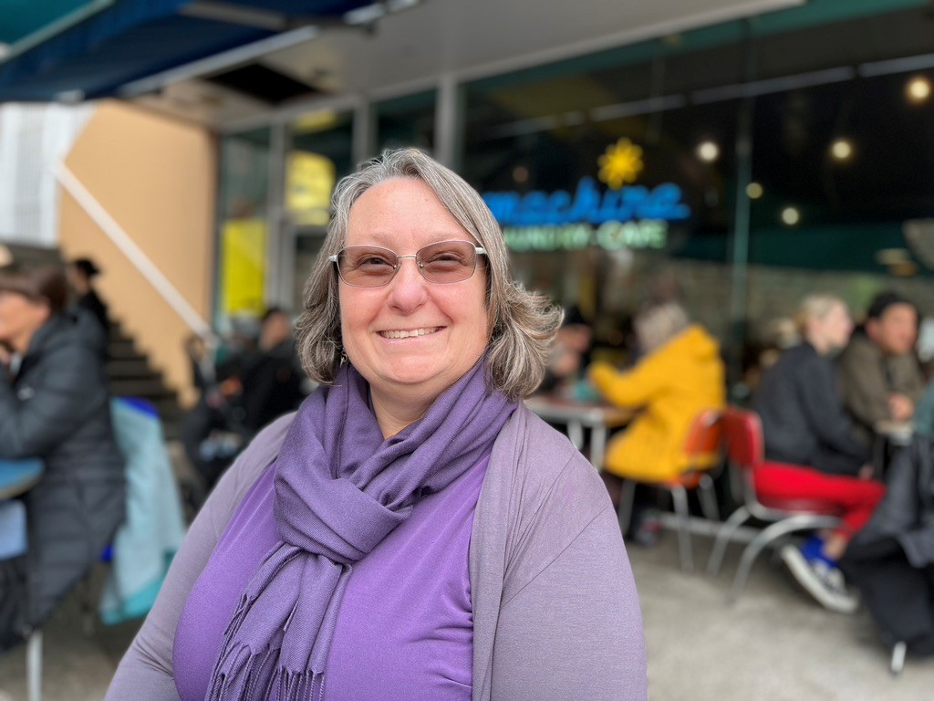 Karyn Willins standing outside a café, smiling warmly.